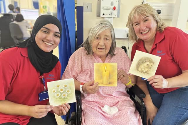 NGH patient Chris Richardson pictured receiving her cards from volunteers Laila and Tracey.