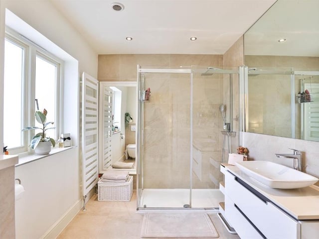 This modern family home is in a picturesque village and shares its boundary with a church.