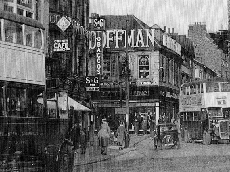 1930s-looking cars and buses travelling through Mercer's Row/Wood Street.