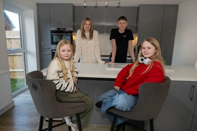 Aimee Fogg and her children Oliver, 14, Maisie, 12, and Isabella, 7, in the kitchen of their new four-bedroom detached home at Davidsons Homes’ Kirby Woodlands development in Northamptonshire