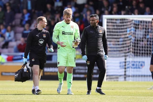 Lee Burge walks from the pitch with physio Ethan Cooper and doctor Sahil Gupta. (Photo by Pete Norton/Getty Images)