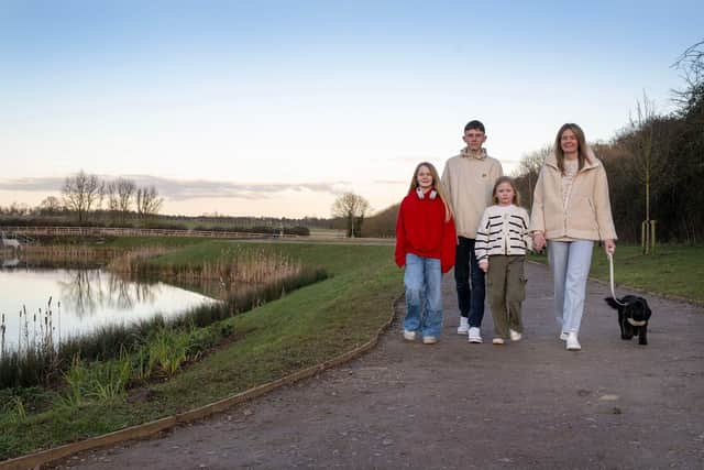The fogg family out walking their dog Lyla beside the lake at Davidsons Homes’ Kirby Woodlands development in Northamptonshire