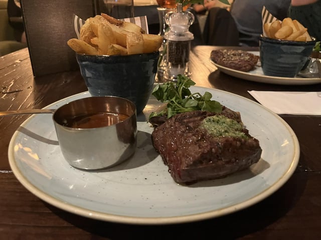 28 day-aged 7oz fillet steak served with rustic thick-cut chips, beef dripping pangrattato shallots, exotic mushrooms, parsley butter and beef dripping sauce.