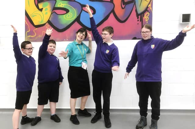 Cathy Rideout, Greenfields Teaching Assistant and leader of the SIGNING Stars choir, with pupils.