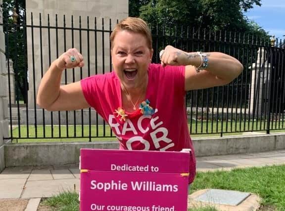 Sophie with a Race for Life sign that will be displayed on the course