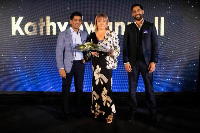 Kathy Swannel receiving her award from Nasir Quraishi and Bilal Tahir