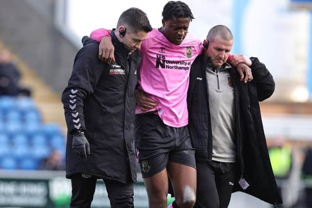 Tyler Magloire limps off the pitch after suffering a serious knee injury against Colchester in February