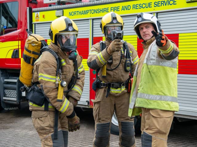 Firefighters discussing tactics at an incident in front of a fire engine