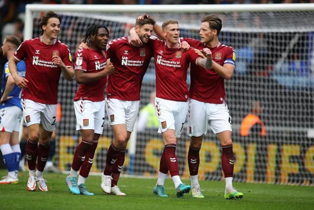 Jon Guthrie celebrates with his team-mates after putting Cobblers 1-0 up at Oldham. Picture: Pete Norton.