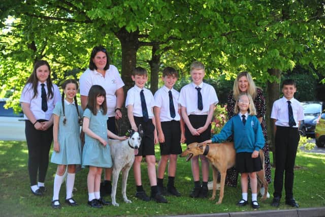 Nicholas Hawksmoor Primary School pupils pose with current racer Pablo The Pup (right) and retired greyhound Marco, plus local trainer Heather Dimmock.