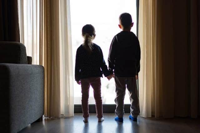 Two children looking out of a window