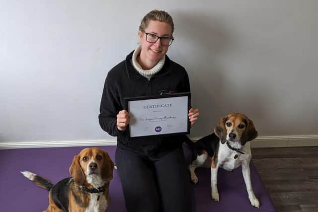 Chloe with her dogs in the clinic with her certificate