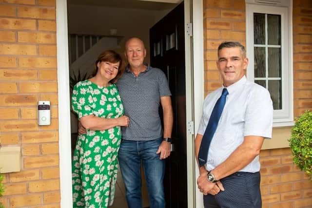 Gail and Garry outside their new home with site manager John