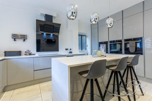 The contemporary kitchen comes complete with modern gloss units and cabinets, complementary worktop over, inset sink and drainer, and electric hob with extractor fan.
