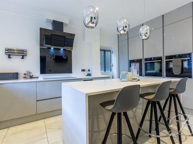 The contemporary kitchen comes complete with modern gloss units and cabinets, complementary worktop over, inset sink and drainer, and electric hob with extractor fan.