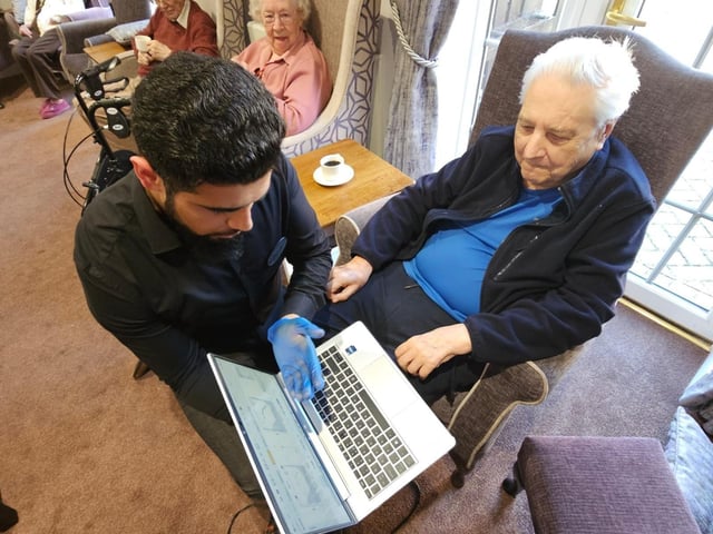 Mabil explains to the home resident ambassador the function of the testing