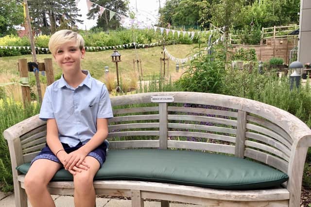 William seated on one of his named benches