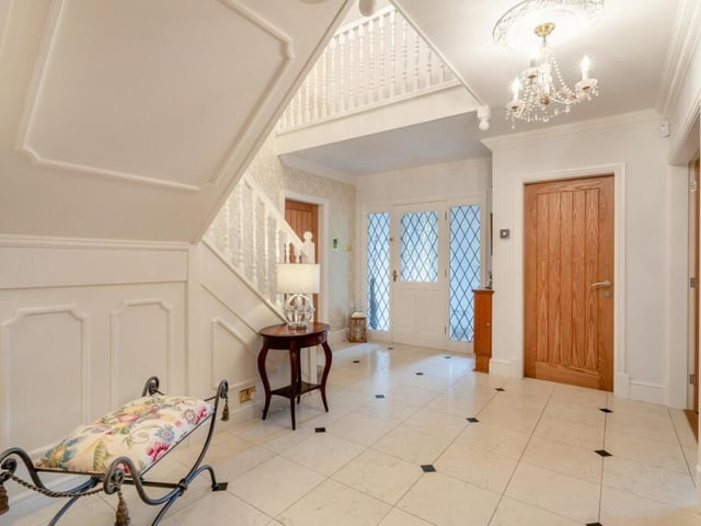 The entrance of the property features white panelled walls and marble flooring