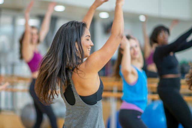 Multiple people stretching at the gym