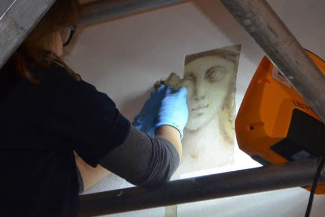 Conservator working to reveal wall paintings at Stowe House.
