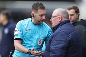 Referee Simon Mather speaks to Steve Evans