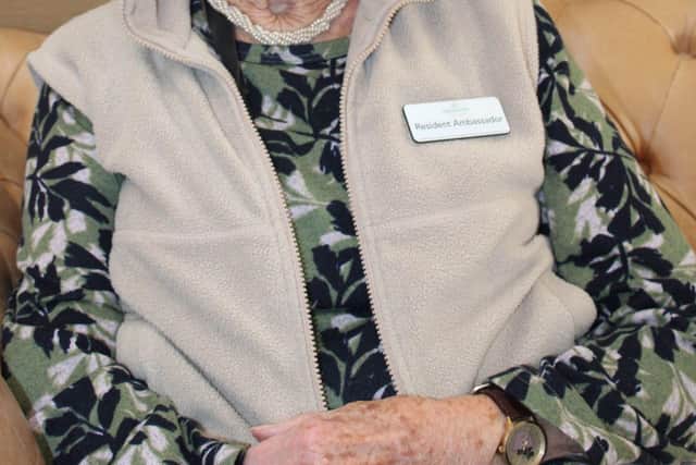 Janet sitting proudly with her Barchester Resident Ambassador Name Badge