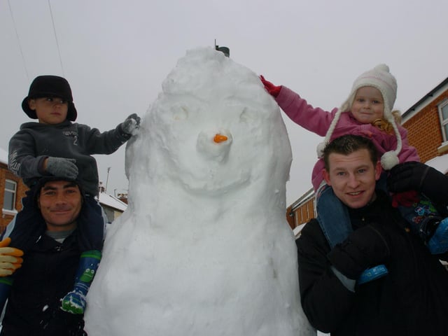 Jack Murray, four, climbs abroad Dave Murray's shoulders and Millie Ibbeson, two, climbs onto Michael Hamilton's shoulders to reach the top of their giant snowman. Thursday, 5th February 2009