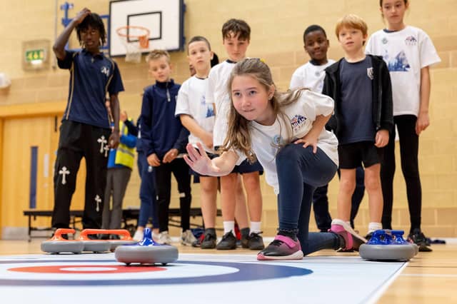 Children try out curling in activity programme running up to the Winter Olympics