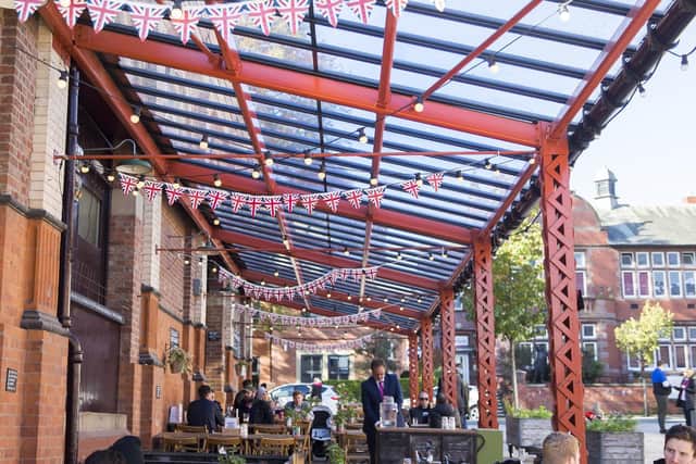 Tables and chairs line the streets, next to Market House, for diners to eat outdoors. The food market has been a catalyst for a new cafe culture in the town.