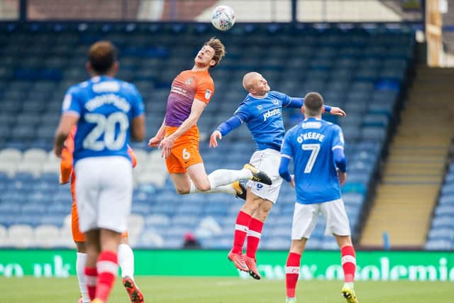 Ash Taylor challenges for the ball with Pompey's Curtis Main
