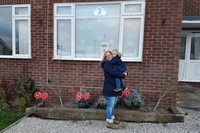 Cat Sabine with her son, Leo, outside their home in Barby