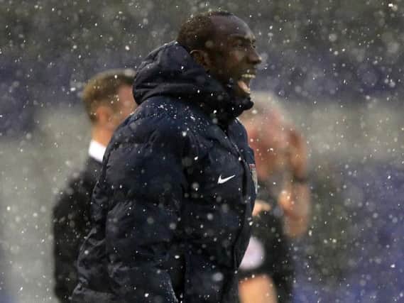 Cobblers boss Jimmy Floyd Hasselbaink watches his team suffer a heavy defeat at a snowy Oldham