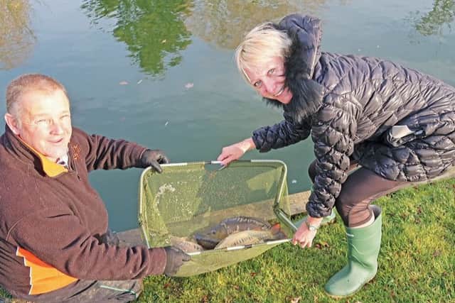 Lakeside co-owner Tina Pentland and Ospreys Ian Millin adding more carp
