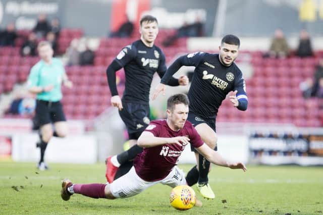 Chris Long is nudged to the ground by Wigan skipper Sam Morsy. Pictures: Kirsty Edmonds