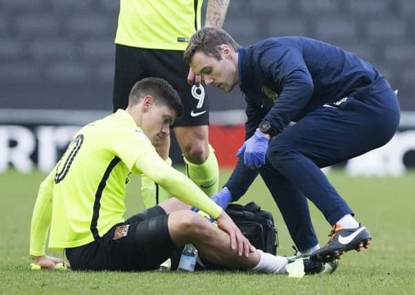 Physio Anders Braastad, pictured here treating Alex Revell, is leaving the Cobblers