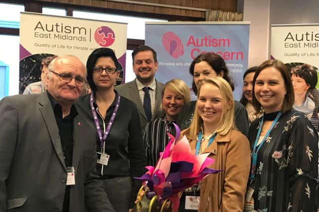 The teams behind Autism Concern and Autism East Midlands, with the ceremonial "torch".
