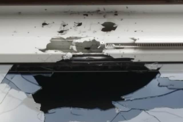 The damage to one of the windows in the pub during the shooting