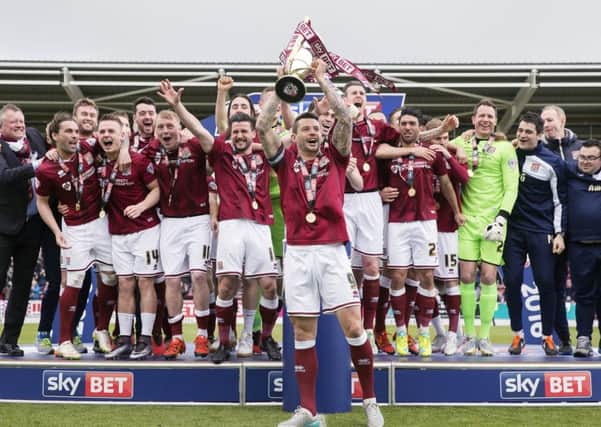 Marc Richards lifts the Sky Bet League Two trophy at Sixfields in April, 2016