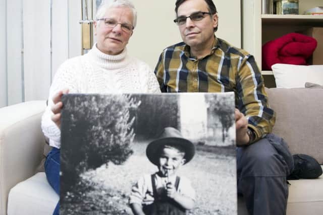 Linda Sgoluppi and son hold a photo of Alberto where he is pictured as a three-year-old in his native Italy.