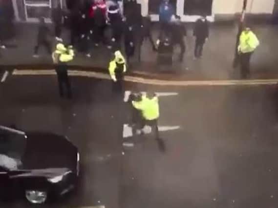 Still image taken of video appears to show police officer shoving MK Dons fan