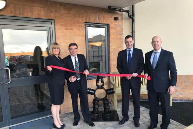 Staff and Dennis Nightingale pictured cutting the ribbon to officially open the care home.