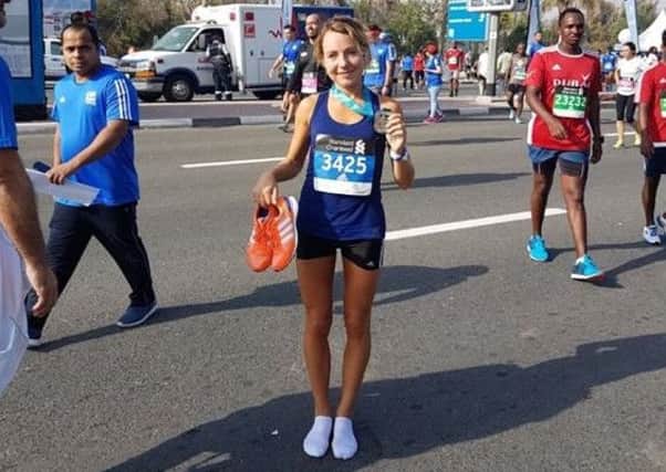 Emily Waugh shows off her medal after finishing the Dubai Marathon
