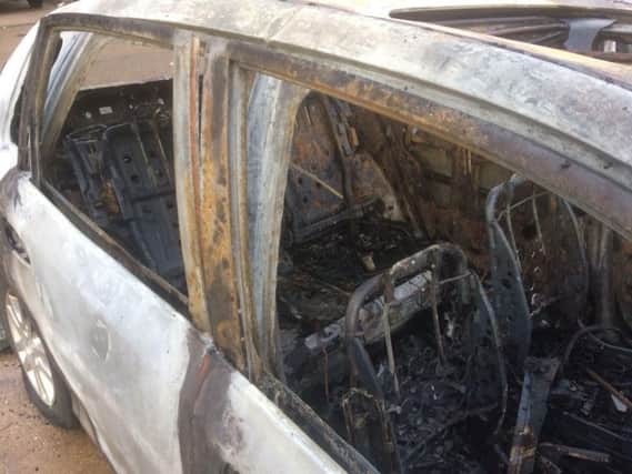 The car's interior has been destroyed by flames.