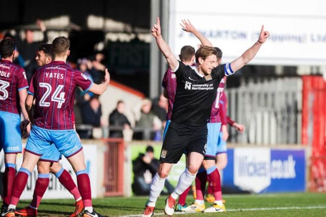 EARLY STRIKE: Ash Taylor shows his delight after Chris Long heads the Cobblers into an early lead at Glanford Park. Pictures: Kirsty Edmonds