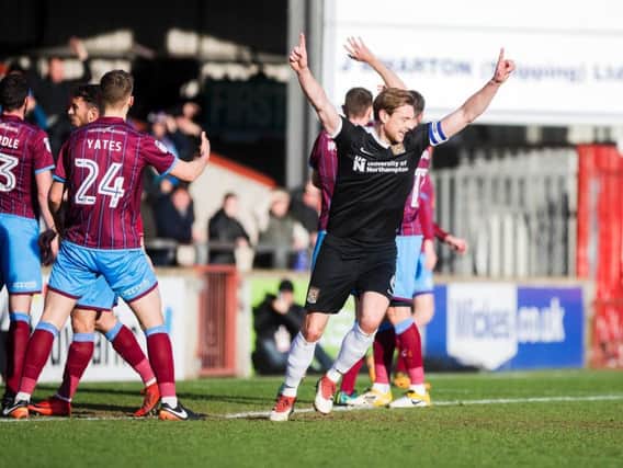EARLY STRIKE: Ash Taylor shows his delight after Chris Long heads the Cobblers into an early lead at Glanford Park. Pictures: Kirsty Edmonds