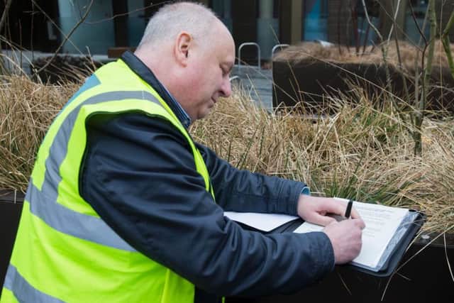 Mr Morrell signs the notices before handing them in to a council officer. (Picture: Leila Coker)