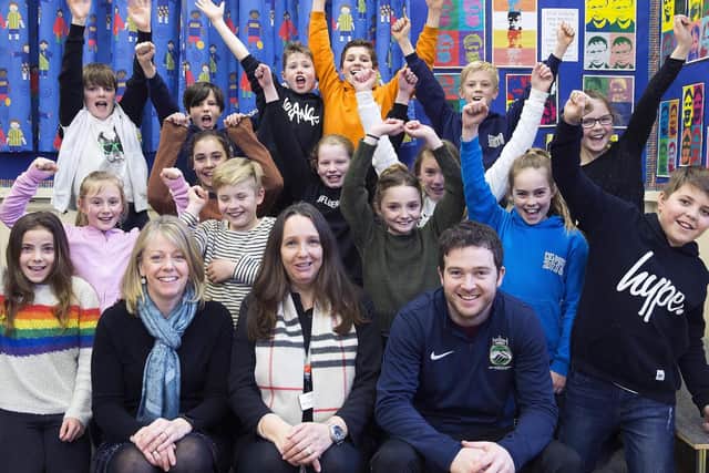 Headteacher Mrs Truslove (centre) pictured celebrating with her teaching staff and children after bagging the top spot in England for reading and maths.