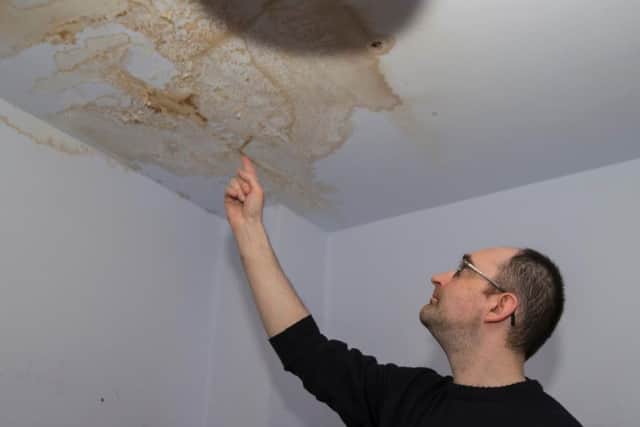 Daniel (pictured pointing at the leak in his bedroom) has turned his ceiling lighting off to prevent any danger.