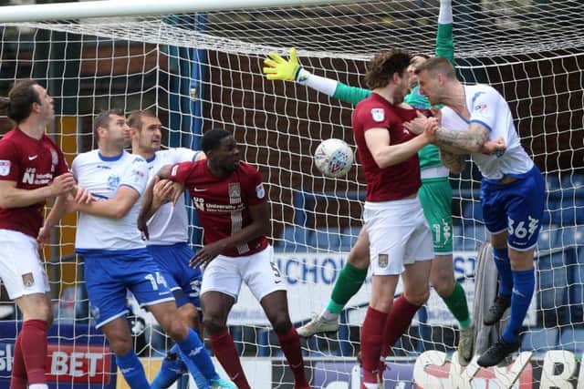 TELLING TOUCH: Ash Taylor glances Matt Grimes' corner into the bottom corner to hand the Cobblers a sixth-minute lead against Bury. Pictures: Sharon Lucey
