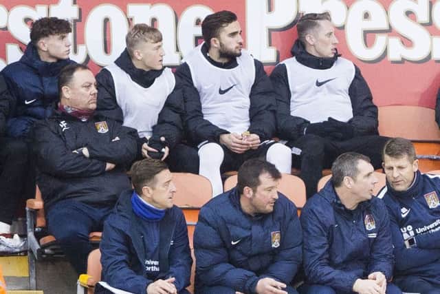 Sean Whaler (top left) watches on from the bench during the Cobblers' loss at Blackpool last month